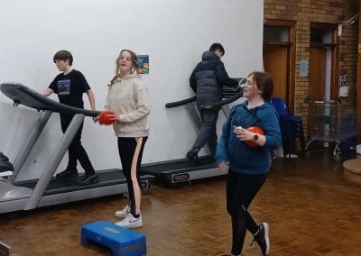 Young people using the treadmills and workout gear in the gym