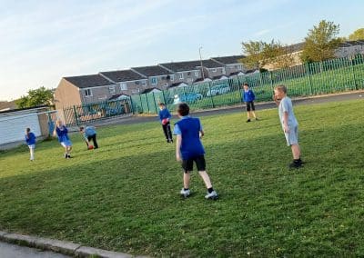 A game of football on the grass outside the centre