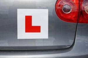 A red L-plate on the back of a learner’s car