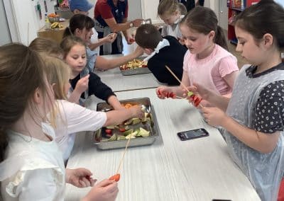 Children threading fruit and vegetables onto skewers