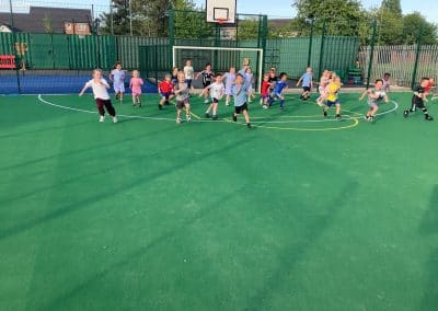 A crowd of children racing across the astroturf pitch