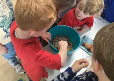 Children mixing ingredients in a big bowl at the craft table
