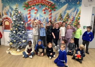 Children posing in front of a North Pole backdrop at the Christmas party