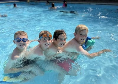 Four children swimming together in the outdoor pool at Skipton