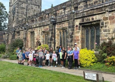 The whole group of children and youth workers outside a Yorkshire stone church