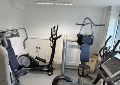 Cross trainer, exercise bike and weights machines lining the gym